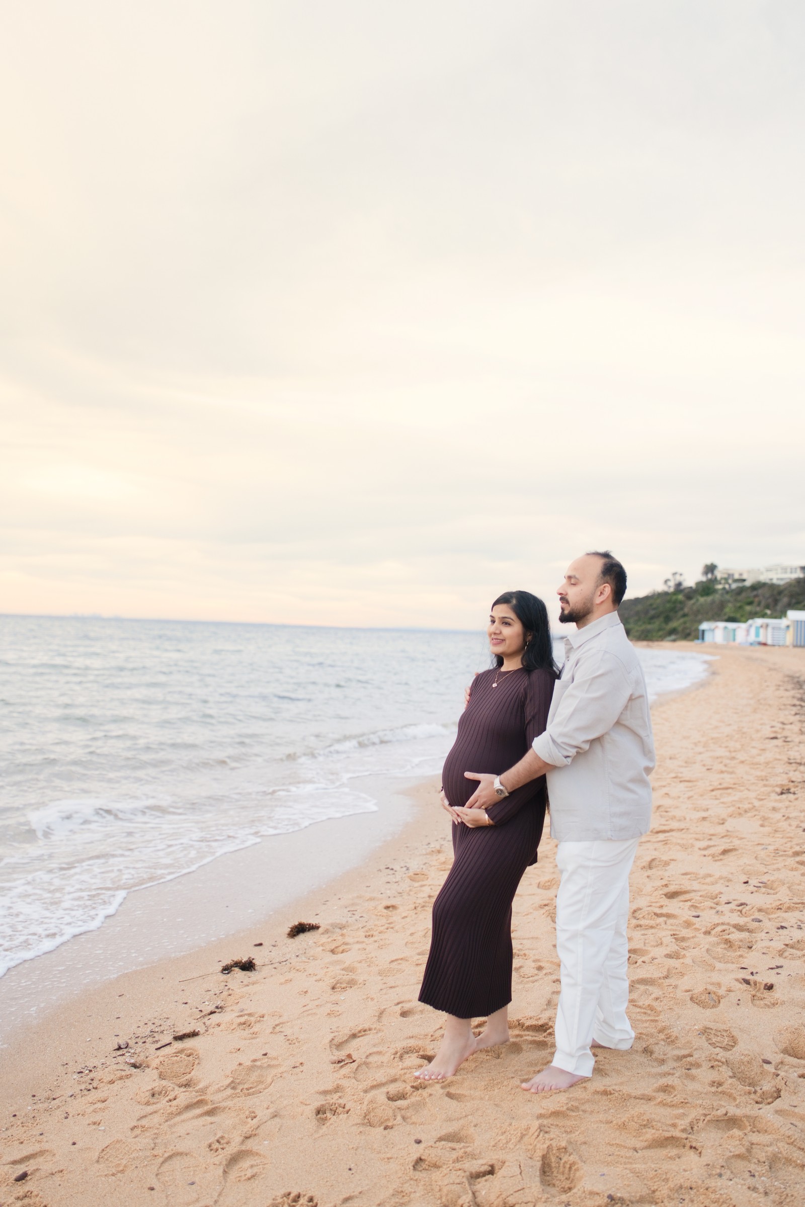 Maulik and Madhvi standing together near the water's edge looking at each other